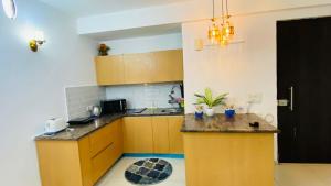 a kitchen with wooden cabinets and a counter top at Zoom Stay Sector 168 Noida 1bhk in Noida