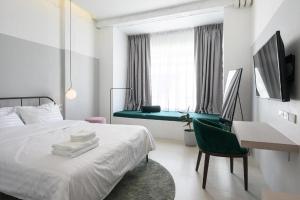 ein Schlafzimmer mit einem Bett, einem Schreibtisch und einem Stuhl in der Unterkunft Our Nomad Boutique Hostel in Phuket