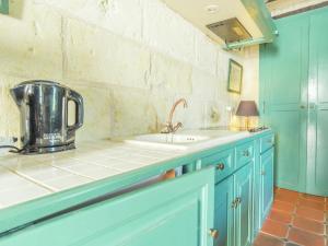 a kitchen with blue cabinets and a sink at Riverside Hideaway in Cinais in La Roche-Clermault