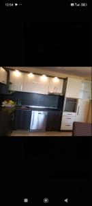 a kitchen with white cabinets and a microwave at Apartman Krstic in Jagodina