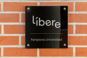 a sign on the side of a brick wall at Líbere Pamplona Universidad in Pamplona