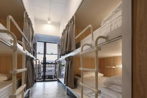 ein Zimmer mit vier Etagenbetten und einem Fenster in der Unterkunft Our Nomad Boutique Hostel in Phuket