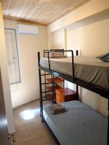 two bunk beds in a small room with a window at Jenny's House in Skiathos Town