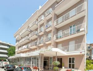 a building with balconies and cars parked in front of it at Hotel Dell'Angelo in Rimini