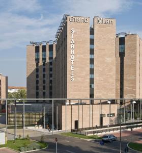 a large building with a sign on top of it at Starhotels Grand Milan in Saronno