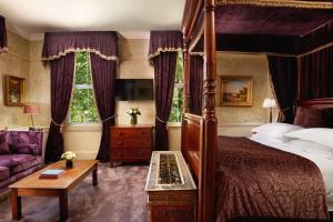 a bedroom with a canopy bed and a purple couch at The Gore London - Starhotels Collezione in London