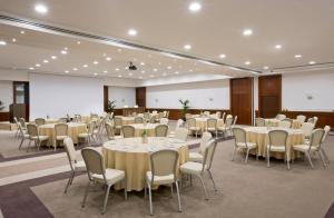 a banquet hall with tables and chairs and a projection screen at Starhotels Majestic in Turin