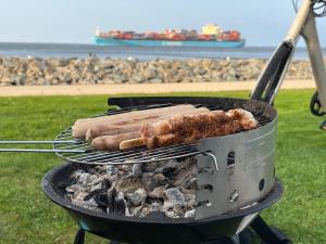 two hot dogs on a grill with a ship in the background at Gasthaus zur Grenze in Cuxhaven