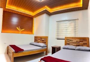 a bedroom with two beds and a window at Chapis Transient Home in Baguio +5 photos