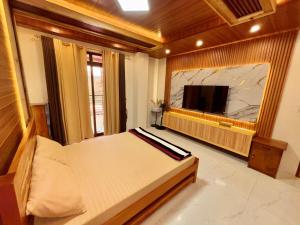 a bedroom with a bed and a flat screen tv at Chapis Transient Home in Baguio