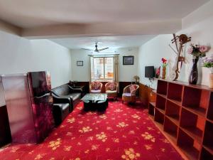 a living room with a couch and a red carpet at Samaritan Guest House in Pātan