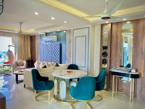 a living room with a couch and a table and chairs at Elysium Tower-Presidential Apartments Facing Centaurus Mall Islamabad in Islamabad