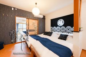 a bedroom with two beds and a black wall at Senjushuku FUJI 201 北千住 in Tokyo +54 photos