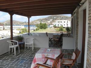 a patio with a table and chairs and a view at Pension Irini-Vicky in Ios Chora