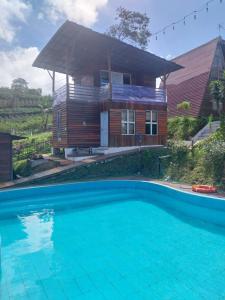 a house with a swimming pool in front of a house at Varvara hill in Cigugur
