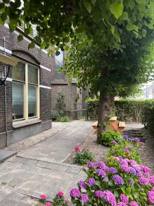 ユトレヒトにあるIn de Pastorie Utrecht - Old rectory, just steps away from the city centerの建物前の木と花