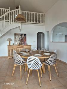 a dining room with a wooden table and chairs at Beautiful sea view building in Le Robert