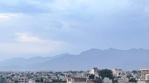 a view of a city with mountains in the background at Veda- Luxurious 4BHK with Ganga & Hill View in Rishīkesh
