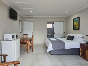 ジョージにあるEasy Stay Guesthouse Georgeのベッドルーム1室(ベッド1台、デスク、電子レンジ付)