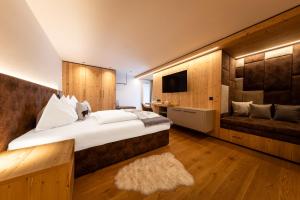 a bedroom with a large bed and a couch at Crëp Sella in Colfosco