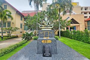 a monument in front of a building with palm trees at Suan Sunandha Palace Hotel in Bangkok