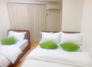 2 letti con cuscini verdi in una stanza di 2F 3 minutes walk from Nishi-Oi Station, Shinagawa Ward, 4 stations available, surrounded by commercial streets, rich life, convenient transportation a Tokyo