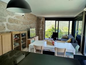 a living room with a white table and chairs at Várzeas Nature House in Soengas