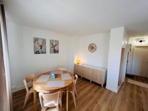 a dining room with a wooden table and chairs at Le Millésime Florence Stationnement in Reims