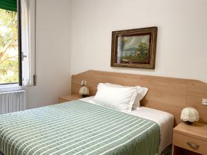 a bedroom with a bed and a picture on the wall at Albergo Edera in Salsomaggiore Terme