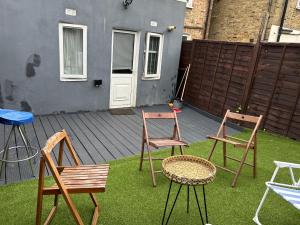 two chairs and a table on a patio at A Cosy Ground Floor Flat in London