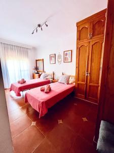 twee bedden in een kamer met rode lakens bij Costa Suri Casa in Nerja +11 foto's