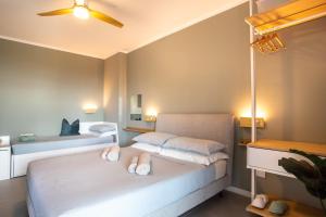 ein Schlafzimmer mit zwei Betten und einem Deckenventilator in der Unterkunft Jesolo Vista Lido - Rooftop Suite in Lido di Jesolo