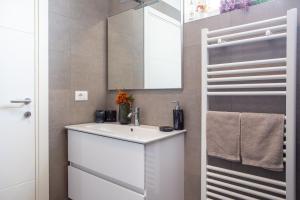 ein Badezimmer mit einem weißen Waschbecken und einem Spiegel in der Unterkunft Jesolo Vista Lido - Rooftop Suite in Lido di Jesolo + 19 Fotos