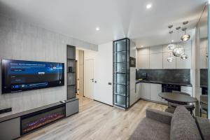 Una sala de estar con un sofá y un televisor. en Petrovdom Apartments 5-123, Building 18, in RC Fayna Town, Saliutna Street 2, en Kiev