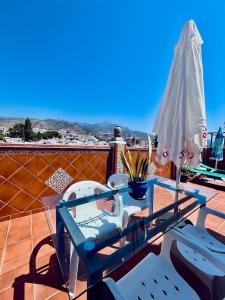 een terrastafel en parasol op een dak bij Costa Suri Casa in Nerja