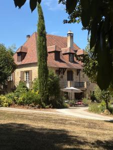 a large house with a tree in front of it at Chambres à la campagne in Marnac +2 photos