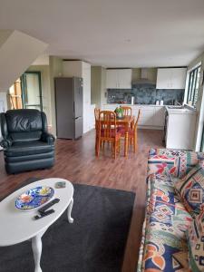 una sala de estar con un sofá y una mesa en Waimate Cottage - Waimate North, en Waimate North