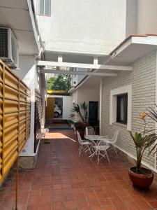 une terrasse ouverte avec une table et des chaises. dans l'établissement Nuevo Hotel Córdoba, à Villa Carlos Paz