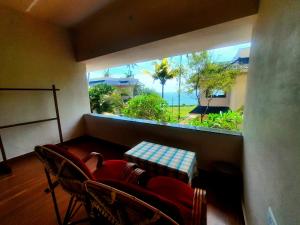 a room with a window with chairs and a table at Seashore Beach Resort Varkala in Varkala