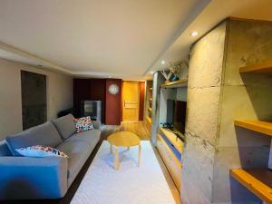 a living room with a couch and a table at Côté Nature in Sciez