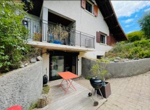 a patio with a red table and a balcony at Côté Nature in Sciez