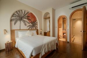 a bedroom with a bed with a palm tree mural on the wall at Ha Long 6BRS Beach Villa With Pool, Jacuzzi and Sauna in Ha Long