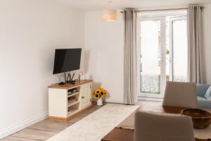 a living room with a tv and a blue couch at Lovely apartment in Seaton