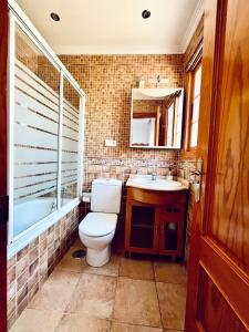 a bathroom with a toilet and a sink and a mirror at Costa Suri Casa in Nerja