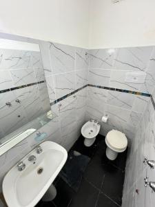 a white bathroom with a sink and a toilet at Nuevo Hotel Córdoba in Villa Carlos Paz +44 photos