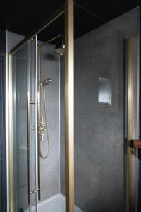a shower with a glass door in a bathroom at Lovely apartment in Seaton
