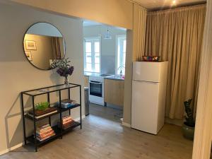 a kitchen with a white refrigerator and a mirror at A cosy flat in the heart of Stavanger in Stavanger