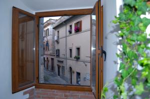 a window with a view of a building at B&B Chiostro San Marco in Tarquinia