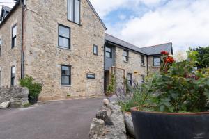 an old stone building with flowers in front of it at Lovely apartment in Seaton