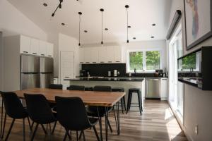 Una cocina con una mesa y sillas de madera. en Spa and Lakefront - Oasis des chutes, en Lac-Saint-Paul